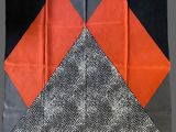 an orange, black, and grey square scarf with a black and white design