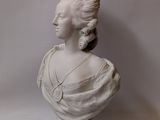 white marble bust of a woman with a crown on her head