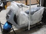 un scooter emballé dans du plastique et posé sur un chariot
