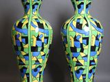 une paire de vases ornés de motifs colorés sur fond gris