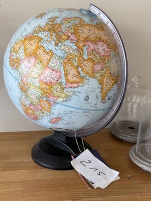 un petit globe terrestre posé sur une table, avec une étiquette de prix dessus