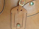 a brown bag with a tag hanging from it ' s handle