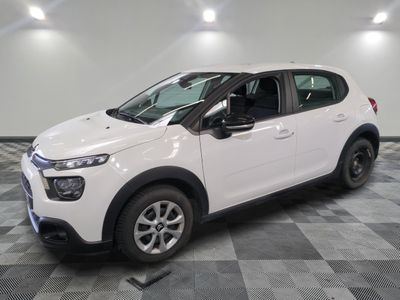 la petite voiture blanche est garée dans une grande pièce