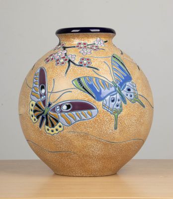 un vase orné d'un motif de papillon, posé sur une table