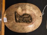 une plaque en bronze sur laquelle figure le portrait d'une tête d'homme