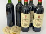 quatre bouteilles de vin sont alignées sur une surface blanche