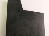a close up of a piece of black paper on a white surface