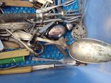 a blue container filled with silver spoons and other silverware