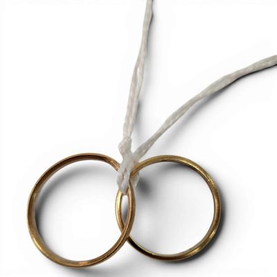 two pairs of gold wedding rings tied to a string