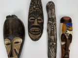 three african masks are displayed on a white surface