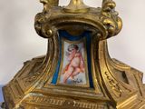 a gold clock with a picture of a woman on it