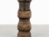 un vase en bois posé sur un sol en béton