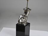 a silver vase with a lamp on top of it