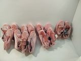 Plusieurs paires de chaussons de danse roses sont alignées en rangée