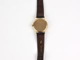 an image of a watch on a white surface with a brown strap