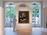 a painting of a man standing in a room with a painting on the wall