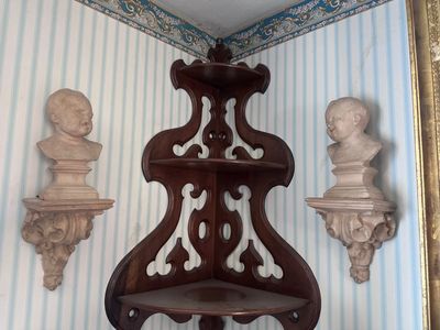 a shelf that has two busts and a mirror on it