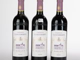 trois bouteilles de vin posées sur une table blanche