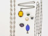 plusieurs colliers et bracelets différents disposés sur une surface blanche