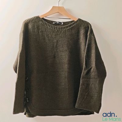 an image of a sweater hanging on a hanger on a wall