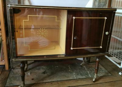 une armoire avec une porte vitrée posée sur un parquet