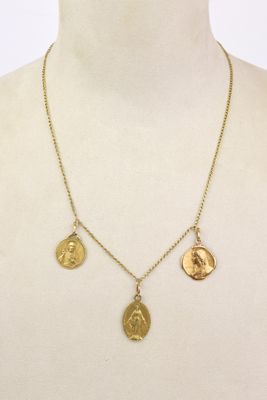 une femme portant un collier en or orné de trois pièces d'or