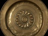 a close up of a gold plate on a black background