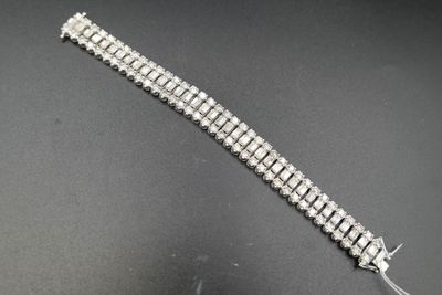 gros plan d'un bracelet en argent sur une surface noire