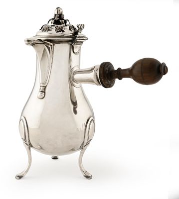 une cafetière ancienne en argent avec une poignée en bois sur un support