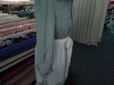 a mannequin in a clothing store with many different fabrics