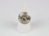 a close up of a ring with a green stone in it
