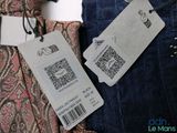 two pairs of jeans with price tags on them sitting next to each other