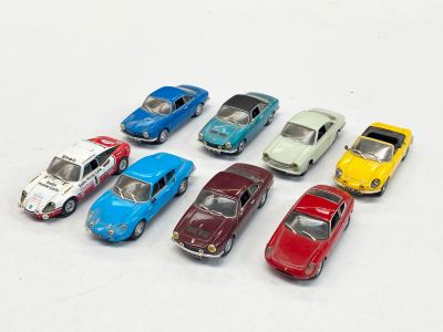 plusieurs petites voitures sont alignées sur une surface blanche