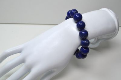 bracelet composé de lapis-lazuli et de perles de verre bleues, présenté sur la main d'un mannequin