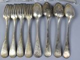 five silver spoons and six silver spoons on a table