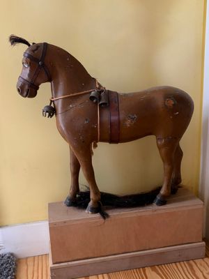 a wooden horse that is standing on a box