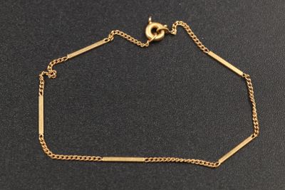 un bracelet plaqué or avec une chaîne sur un fond noir