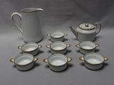 de nombreuses tasses et un pichet posés sur une table