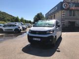 une camionnette blanche garée devant un bâtiment dans un parking