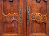 pair of antique wooden doors with ornate carvings on each side