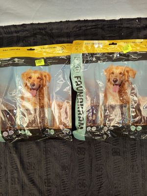 two bags of dog food sitting on top of a bed