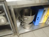 a large metal bowl sitting on top of a metal shelf