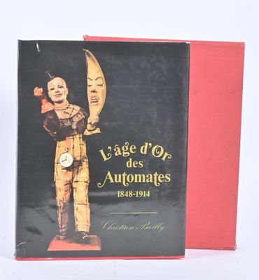 Le livre est posé sur une table, à côté d'une boîte rouge.