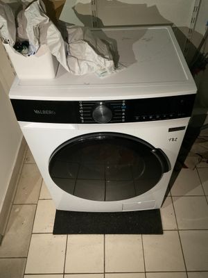 une machine à laver posée sur un sol carrelé