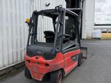 a red forklift truck parked in front of a building