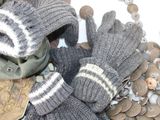 a pile of coins and a pair of gloves on a table