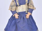 an image of a doll of a little girl in a blue dress