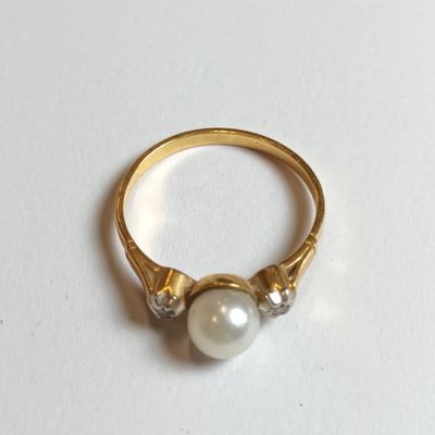 une image représentant une bague en or ornée de deux perles
