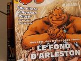 a comic book sitting on the floor next to a bottle of beer