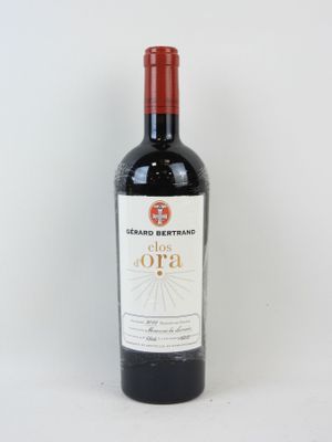 la bouteille de vin rouge est posée sur une surface blanche